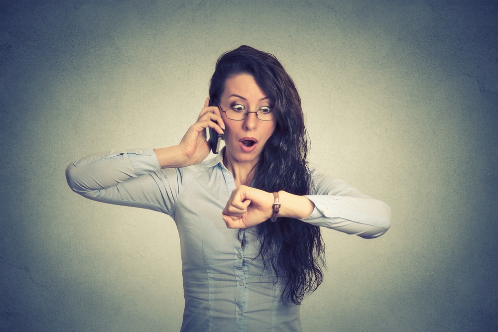 Business and time management concept. Stressed businesswoman looking at wrist watch, running late for meeting-1